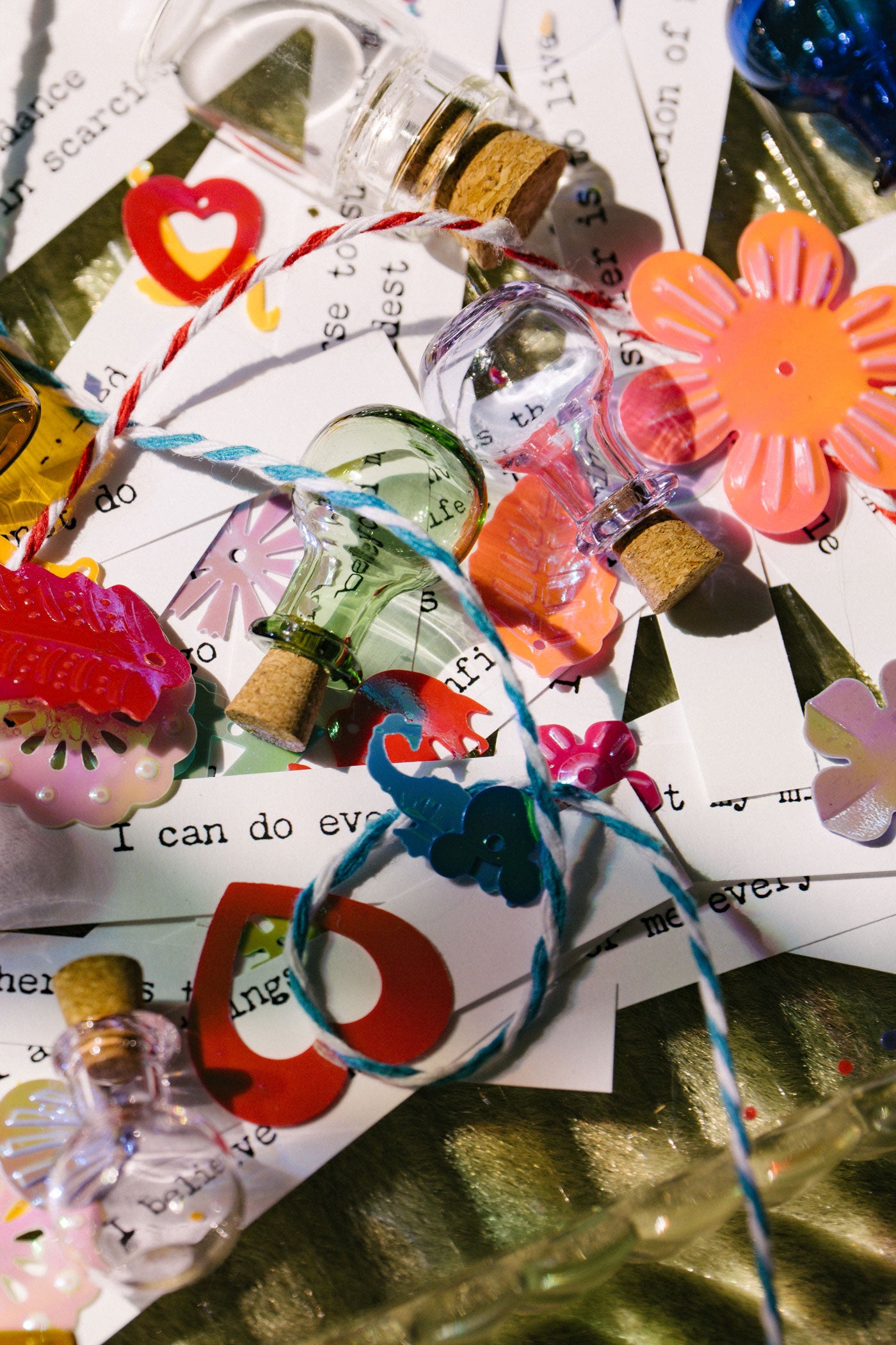 Colorful decorative items including flowers, ribbons, and small bottles on a textured surface.